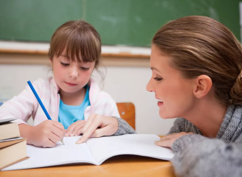 Девочка делает уроки с учителем